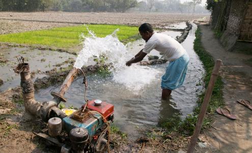 Man washing hands at motorized water pump Bangladesh